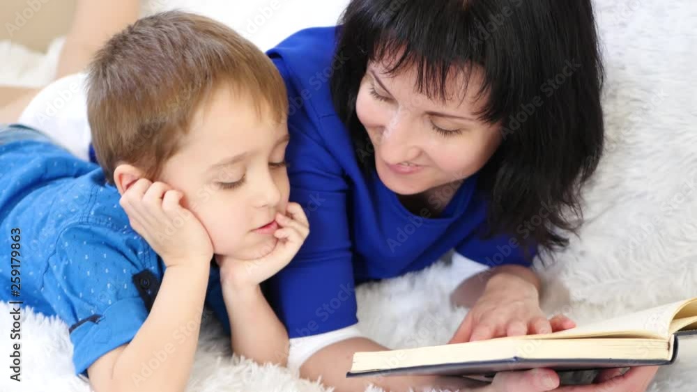 Portrait of a happy family. Mother reads a book to her child. Close-up. Portrait of a happy family. Mother reads a book to her child. Close-up.