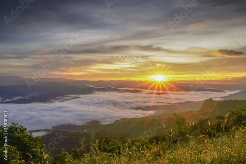 Mountain view morning of the hills around with sea of mist and soft yellow sun light in the sky background, sunrise at Doi Samur Dao, Sri Nan National Park, Nan, Thailand. © Yuttana Joe