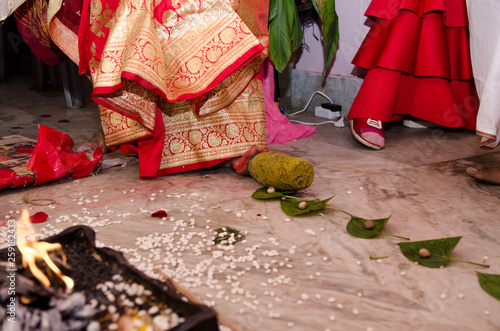 Indian wedding rituals, Gruha Pravesh / Gruhapravesh / Griha Pravesh, closeup picture of right feet of a Newly married Indian Hindu bride dipping her fit in a plate filled with liquid kumkum then step photo