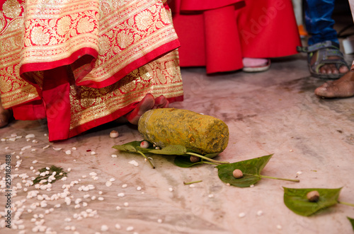 Indian wedding rituals, Gruha Pravesh / Gruhapravesh / Griha Pravesh, closeup picture of right feet of a Newly married Indian Hindu bride dipping her fit in a plate filled with liquid kumkum then step photo