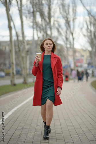 Happy girl floats with coffee down the street © Павел Костенко