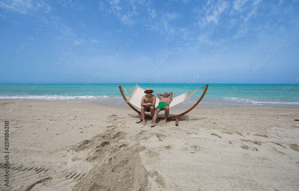 man lying on a hammock resting on the beach man lying on a hammock resting on the beach
