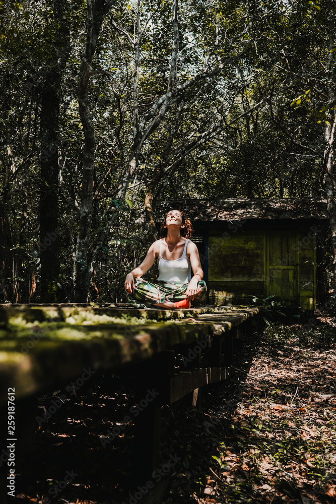 .Young woman enjoying the forest jungle on the island of Borneo, Indonesia. Enjoying a moment of peace on a wooden path prepared to see wildlife of the rainforest. Travel Photography .Young woman enjoying the forest jungle on the island of Borneo, Indonesia. Enjoying a moment of peace on a wooden path prepared to see wildlife of the rainforest. Travel Photography