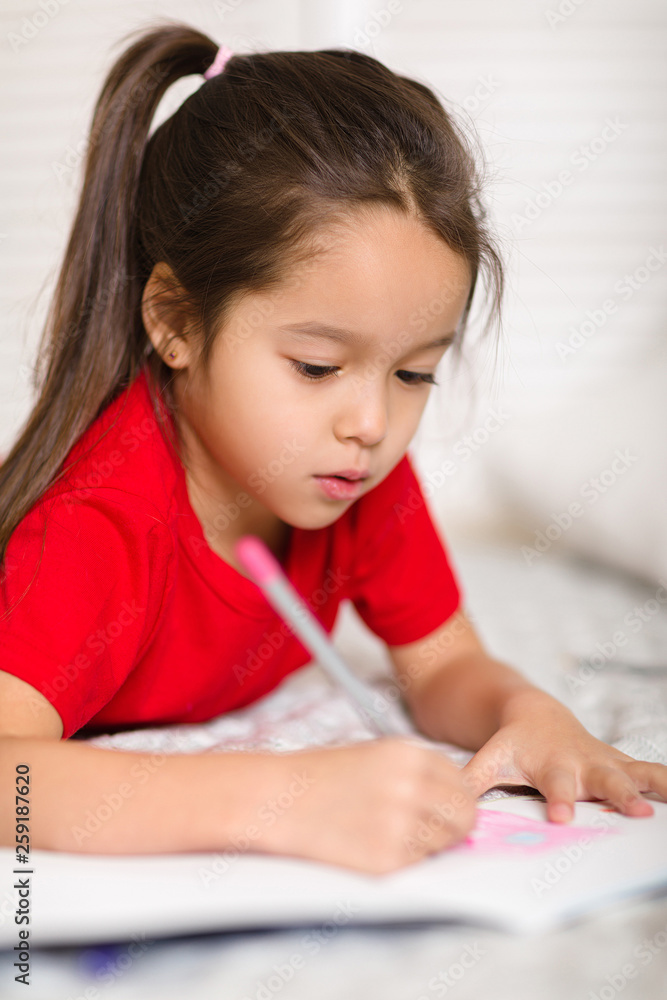 cute little child girl in red pajamas draws with pencils at home cute little child girl in red pajamas draws with pencils at home