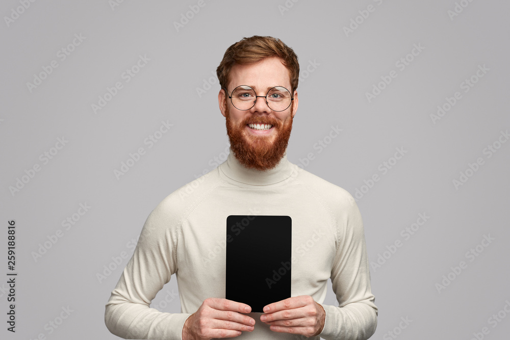Smiling bearded guy showing tablet with empty screen Smiling bearded guy showing tablet with empty screen
