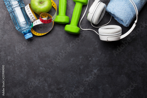Fitness concept. Dumbbells, headphones and apple