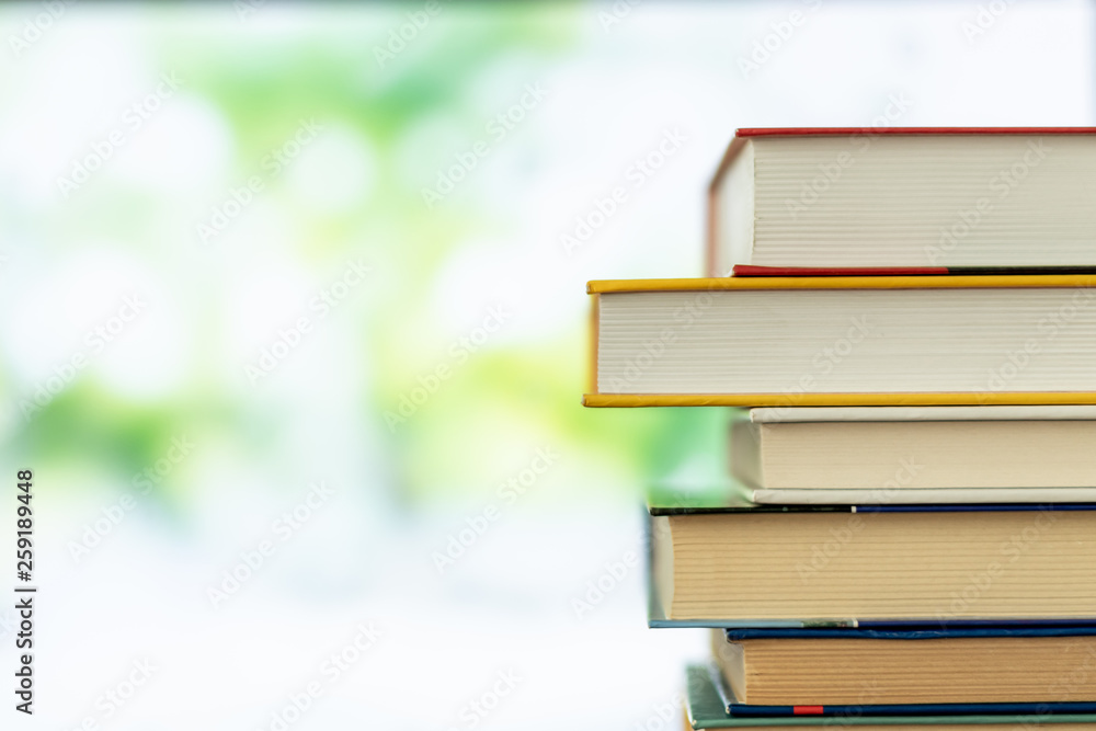Multikolor book stack in the library room on tabel and blurred trees on street back to school concept Multikolor book stack in the library room on tabel and blurred trees on street back to school concept