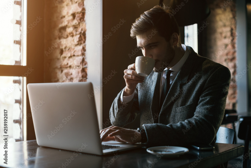 Young businessman working on a plan of Internet project on the laptop. Man discusses business matters by phone. Working computer for internet research. Digital marketing. Development Young businessman working on a plan of Internet project on the laptop. Man discusses business matters by phone. Working computer for internet research. Digital marketing. Development
