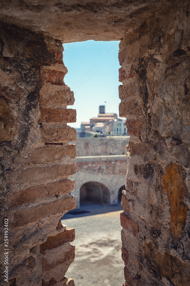A shooting hole in the old city wall of Antibes with a view on the old center
