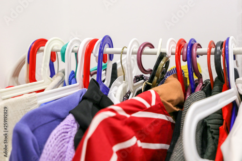 Colorful hangers with variety of clothes. Choice of textile