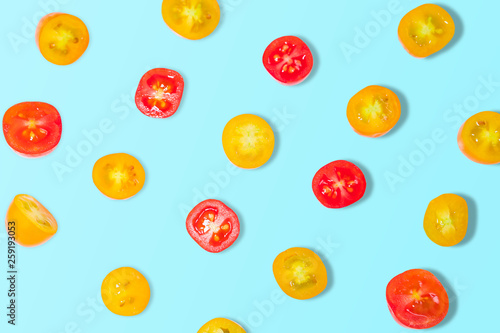 Fresh yellow and red tomatoes on a blue background