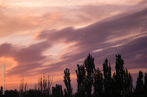 Landscape with dramatic light - beautiful golden sunset with saturated sky and clouds.