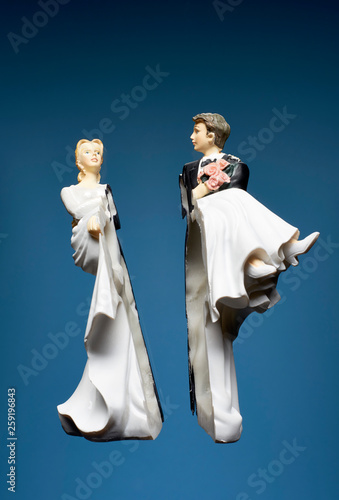 Bride and groom broken figurines against blue background