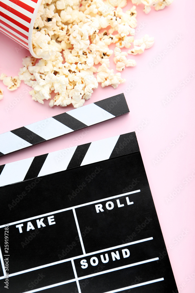 Clapper board with popcorn on pink background