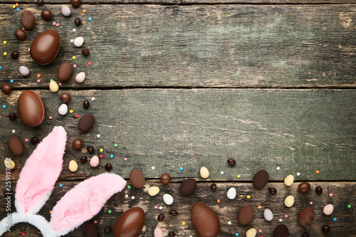 Chocolate easter eggs with rabbit ears on grey wooden table