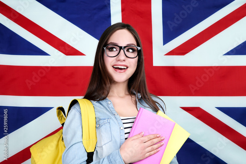 Young student with backpack and books on British flag background