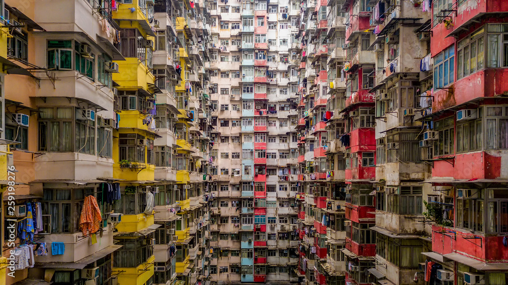 Fototapeta premium Widok z lotu ptaka Yick Fat Building, Quarry Bay, Hong Kong. Dzielnica mieszkaniowa w starym mieszkaniu z oknami. Wieżowiec, wieżowiec z oknami architektury w miejskim mieście.