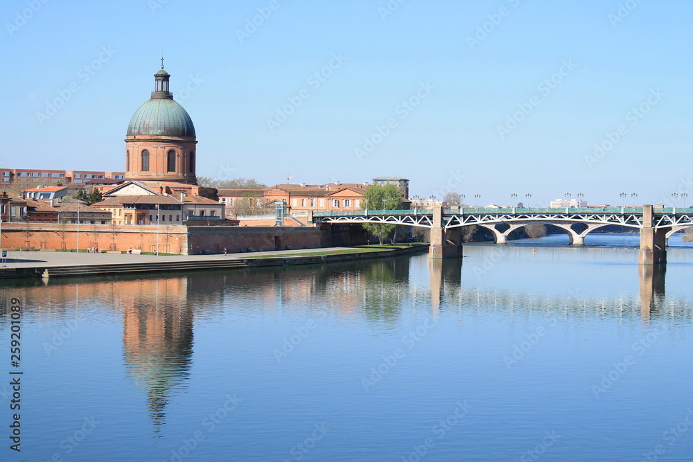Fototapeta premium The Saint Pierre bridge passes over the Garonne river and Hospital de La Grave in Toulouse, Haute Garonne, Occitanie, France