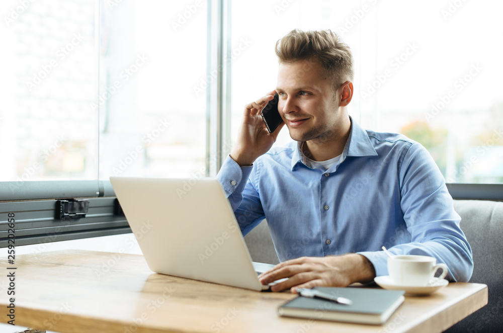 Stylish young man calling by the phone to solve business problems. Online consultation by phone. Freelancer discussing the development and planning of his online project. Outsourcing. Mobile services. Stylish young man calling by the phone to solve business problems. Online consultation by phone. Freelancer discussing the development and planning of his online project. Outsourcing. Mobile services.
