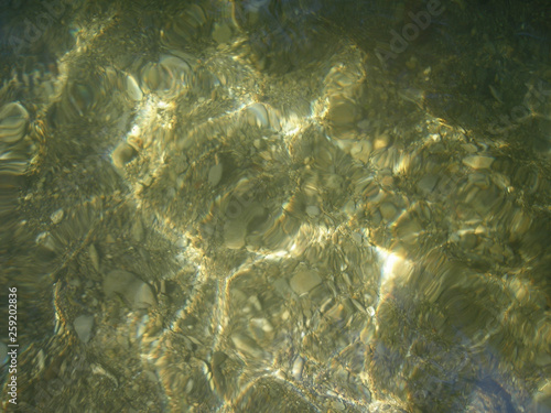 Background sea pebble bottom with sun highlights © Aleksandr Kalegin