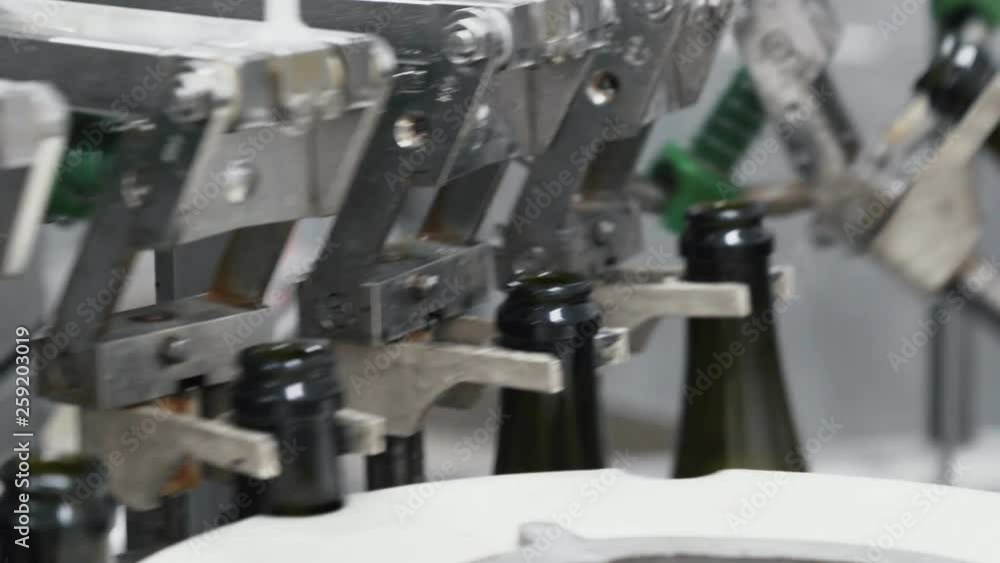 Glass bottles on the automatic conveyor line at the champagne or wine factory. Plant for bottling alcoholic beverages. Glass bottles on the automatic conveyor line at the champagne or wine factory. Plant for bottling alcoholic beverages.