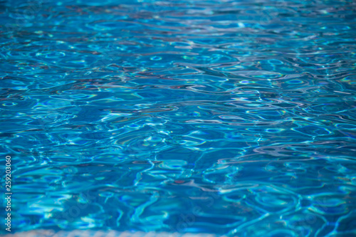 Blurred water texture in summer pool close up.