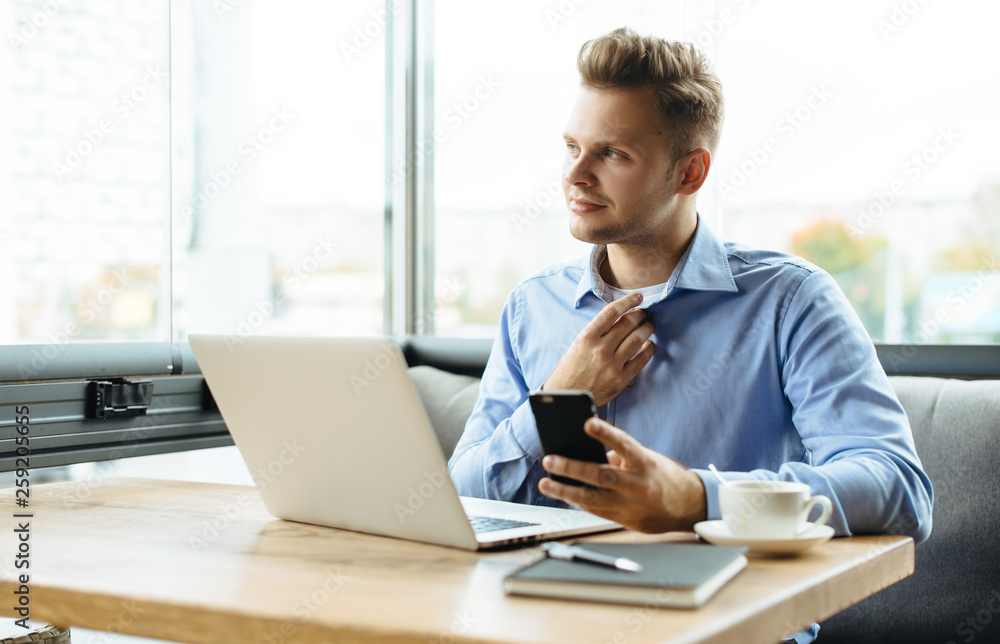 Stylish young man calling by the phone to solve business problems. Online consultation by phone. Freelancer discussing the development and planning of his online project. Outsourcing. Mobile services.