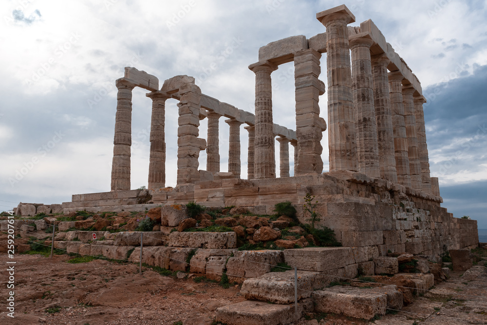 Greek temple ancient stones orange clouds blue sky