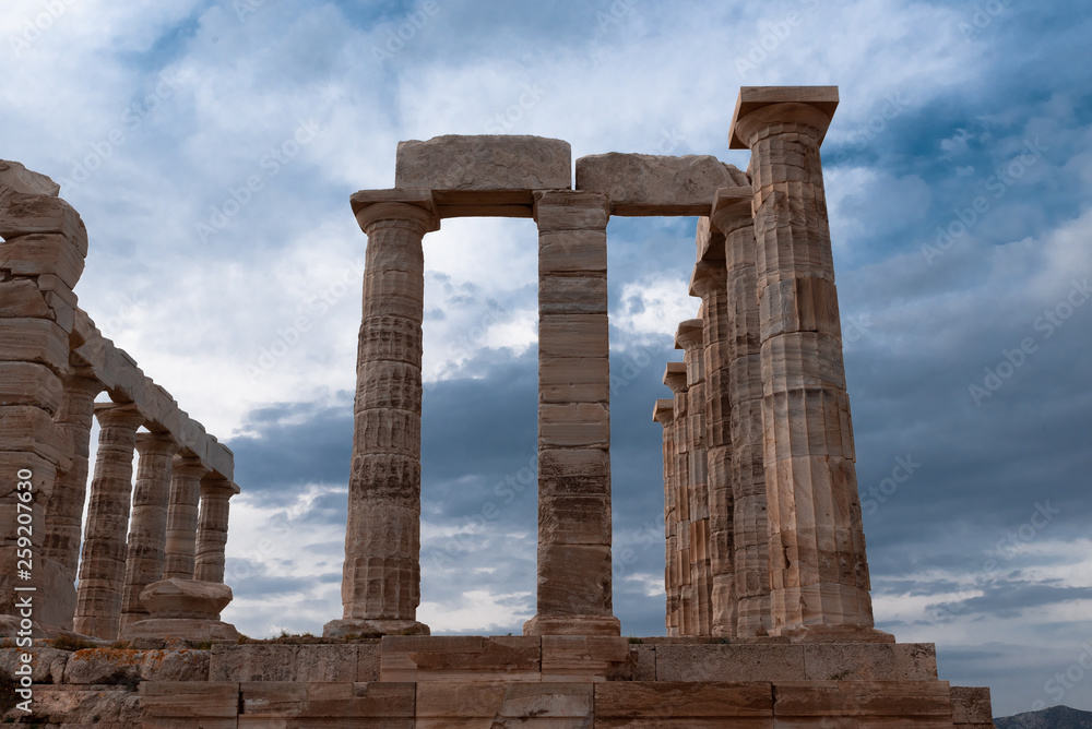 Greek temple ancient stones orange clouds blue sky
