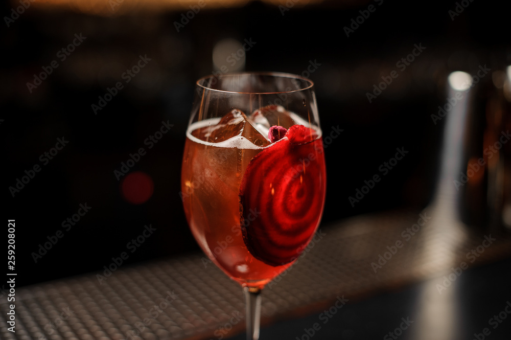 Red cocktail in glass on a bar counter