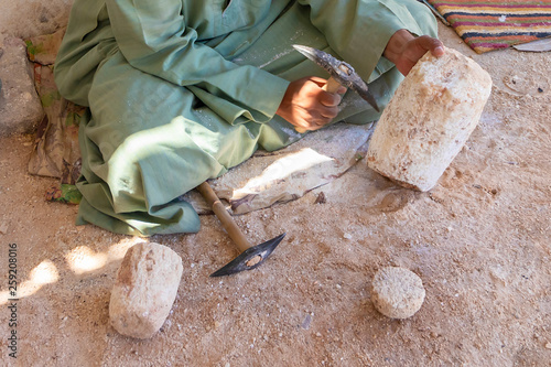 Fotografija Stone carver working with hammer at alabaster column