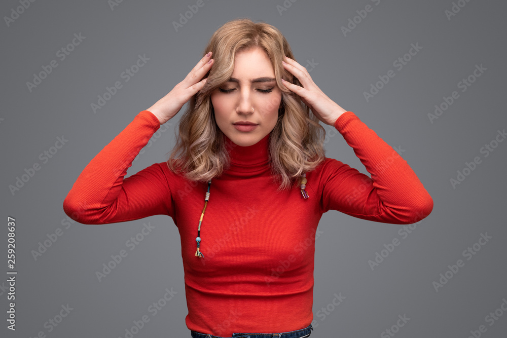 Woman with closed eyes touching head Woman with closed eyes touching head