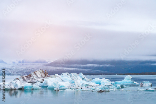 Luminous blue icebergs floating in Jokulsarlon glacial lagoon with background of glacier mountain. South Iceland, Vatnajökull National Park. Copy space background. Place for text.