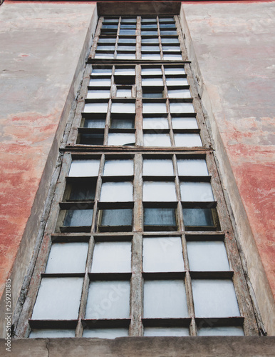 Small windows in an old high-rise building against the bright sky