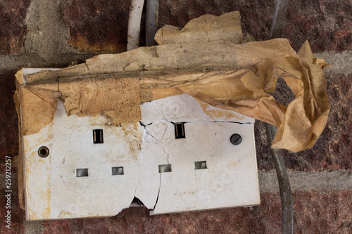 Electricity hazard. Dangerous cracked and damaged electrical power wall socket photo