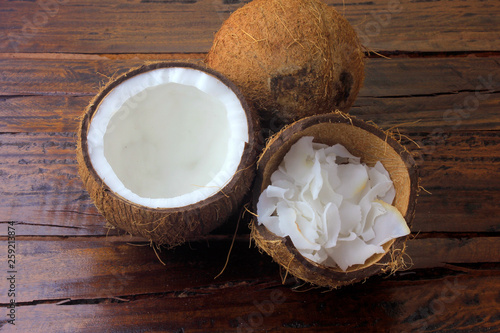 fresh coconut flakes and chips placed in bark isolated on rustic wooden background