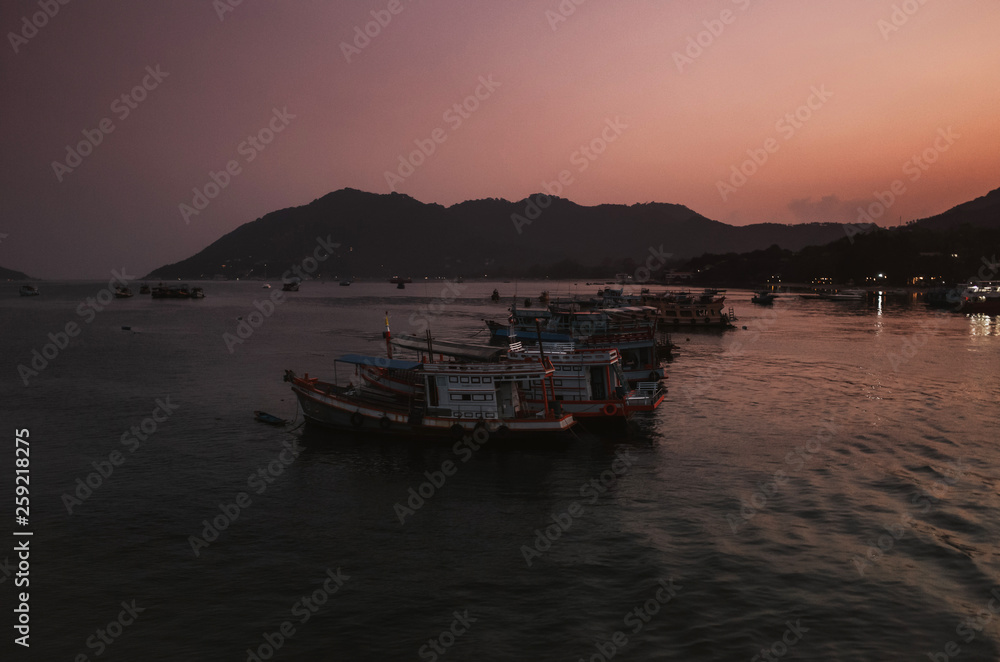 Fototapeta premium tranquil scene of fishing boats during sunrise in a bay in Koh Tao, Thailand
