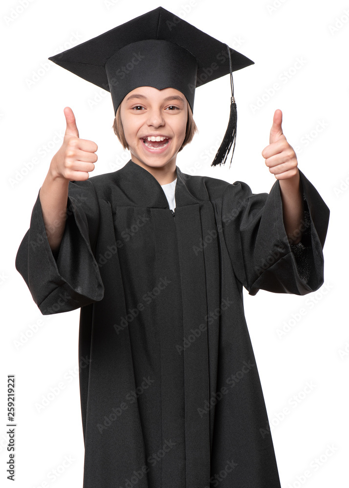 Graduate little happy girl student in black graduation gown with hat making thumbs up gesture - isolated on white background. Child back to school and educational concept. Graduate little happy girl student in black graduation gown with hat making thumbs up gesture - isolated on white background. Child back to school and educational concept.