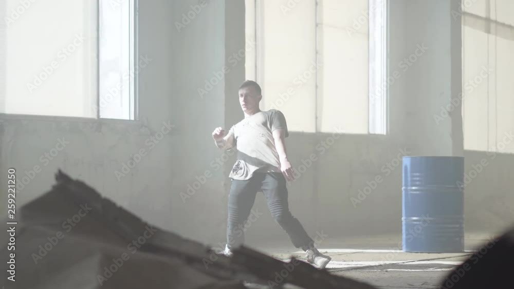 Successful young street hip-hop dancer performing in the fog. Hip hop culture. Rehearsal. Contemporary. Successful young street hip-hop dancer performing in the fog. Hip hop culture. Rehearsal. Contemporary.