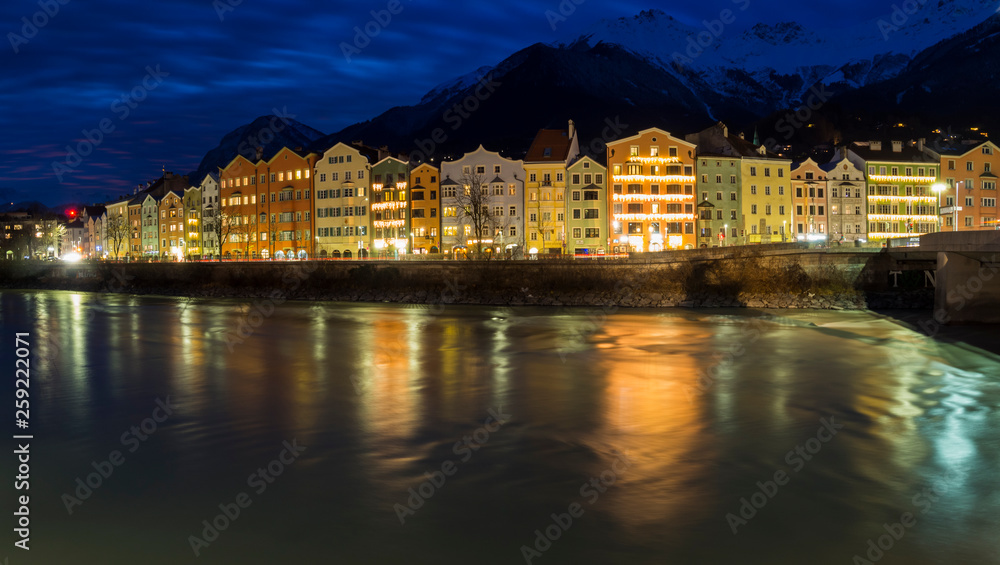 Paisaje al anochecer en Innsbruck, Austria,  con reflejos de las casas de colores en el agua a velocidad de disparo lenta. Diciembre 2018