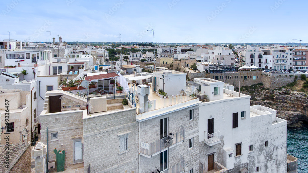 Beautiful view of old town in Polignano a Mare in Italy. Houses and buildings built on cliffs next to ocean or sea. Luxury lifestyle at the edge of the world. Concept of travelling and summer holidays