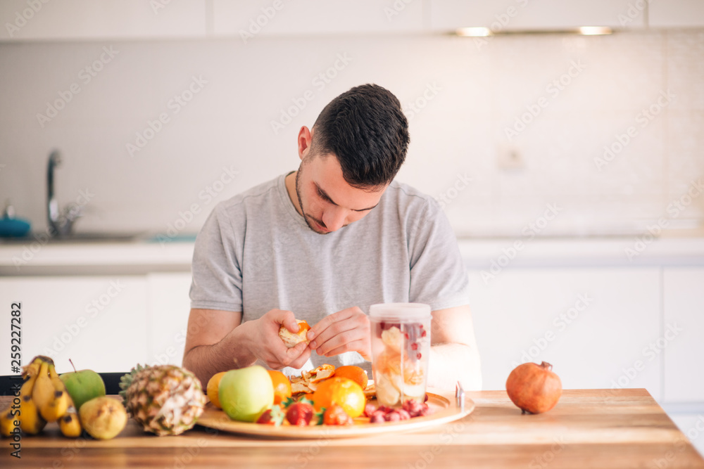 Young caucasian man preparing his healthy smoothie in the morning. Young caucasian man preparing his healthy smoothie in the morning.