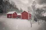 snow in the foreground and three red cottages with forest in the background