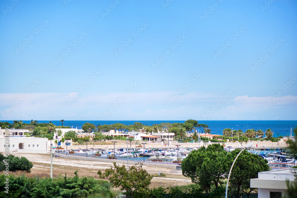 Fototapeta premium Beautiful drone view of harbor and beach side. Houses and buildings with solar panels built next to ocean or sea. Luxury lifestyle. Concept of travelling and summer holidays