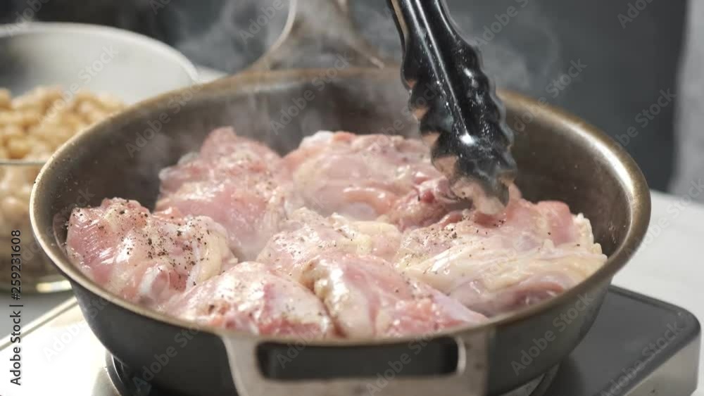 Cooking chicken raw pieces on hot iron pan by chef hands. Food concept video footage for recipe. Cooking chicken raw pieces on hot iron pan by chef hands. Food concept video footage for recipe.