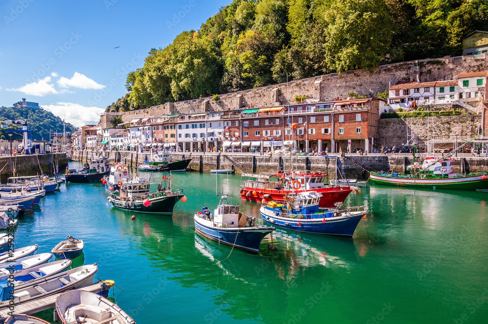 Fototapeta premium Port rybacki Donostia-San Sebastián z łodziami i błękitnym niebem