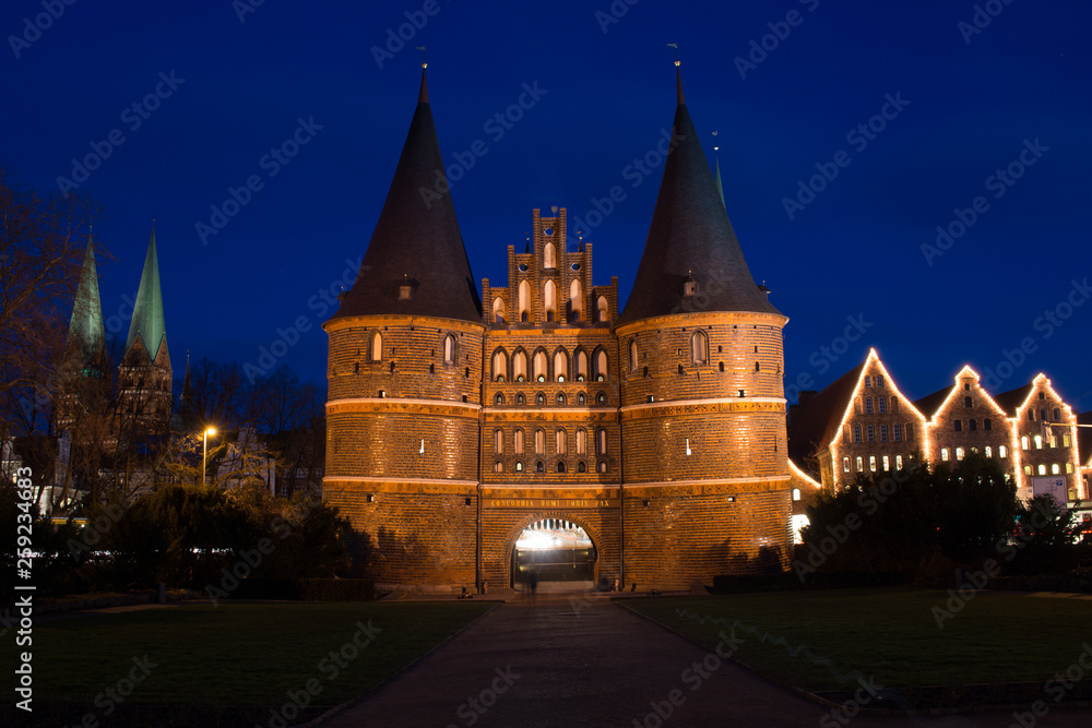 Fototapeta premium Holstentor bei Nacht beleuchtet