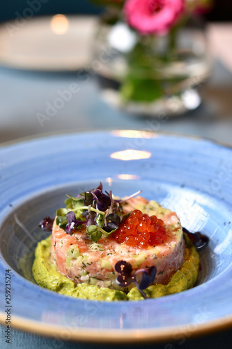 salmon tartare with red caviar on a blue plate