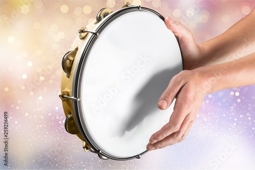 Female hands Playing the tambourine on background