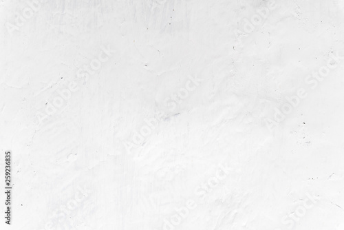 Adobe whitewashed wall in natural white color, traces of brush, texture and background